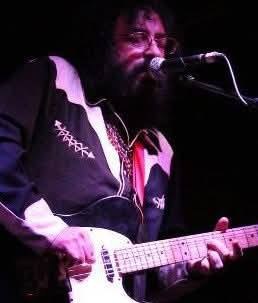 Guy Schwartz performing onstage with guitar